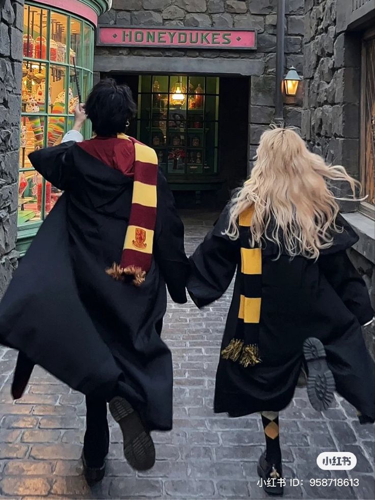 two people dressed in harry potter costumes holding hands