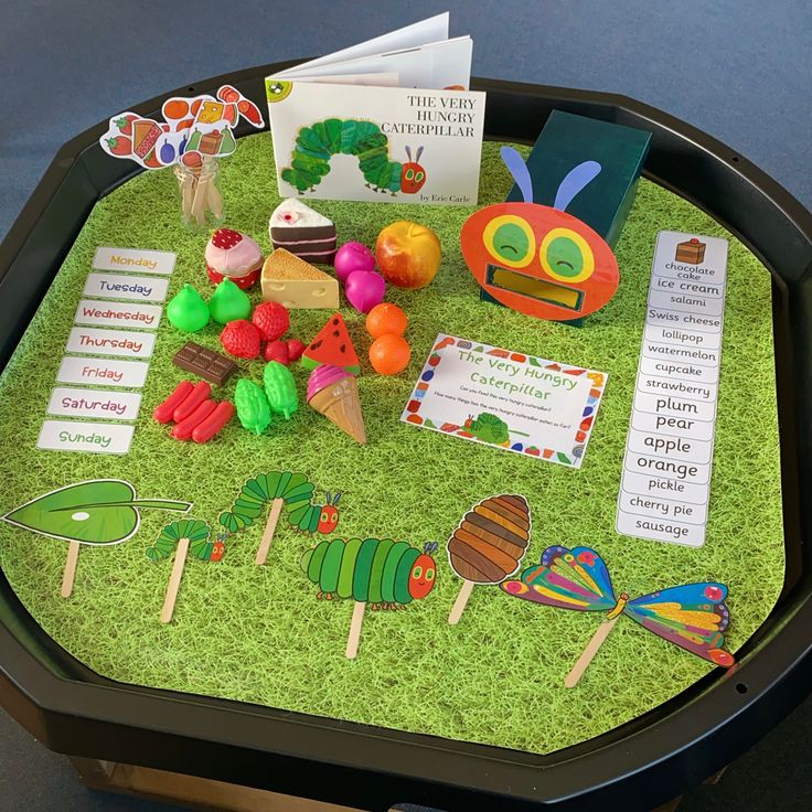 the very hungry caterpillar table is filled with books and crafts