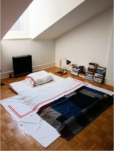 a room with a bed and some books on the floor