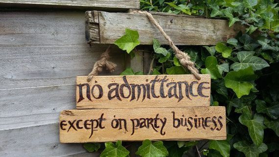 a wooden sign hanging from the side of a building that says no admittance except on party business