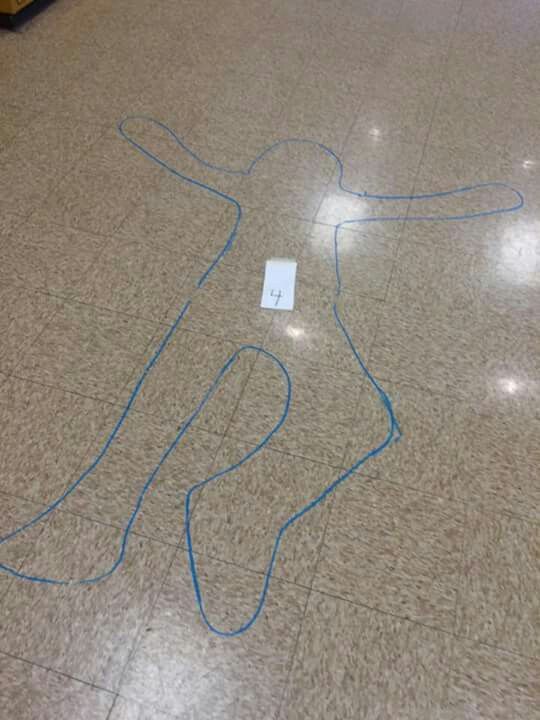 a person's body is drawn on the floor in an airport lobby with blue wires