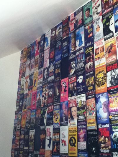 a wall covered in many different movies and posters on it's sides, with the ceiling painted white