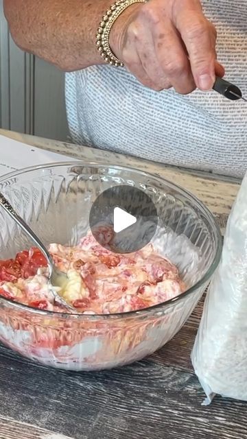 a person mixing food in a bowl with a spoon and plastic bag next to it