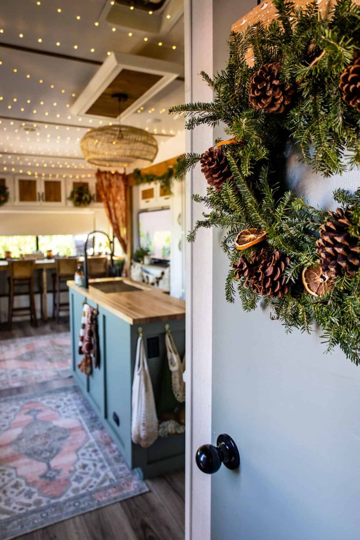 a christmas wreath hanging on the front door of a house with lights in the background