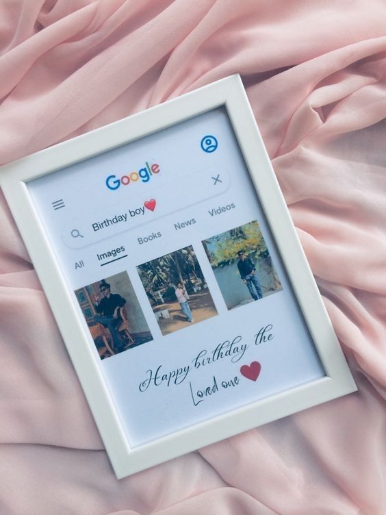 a photo frame sitting on top of a bed covered in pink sheets