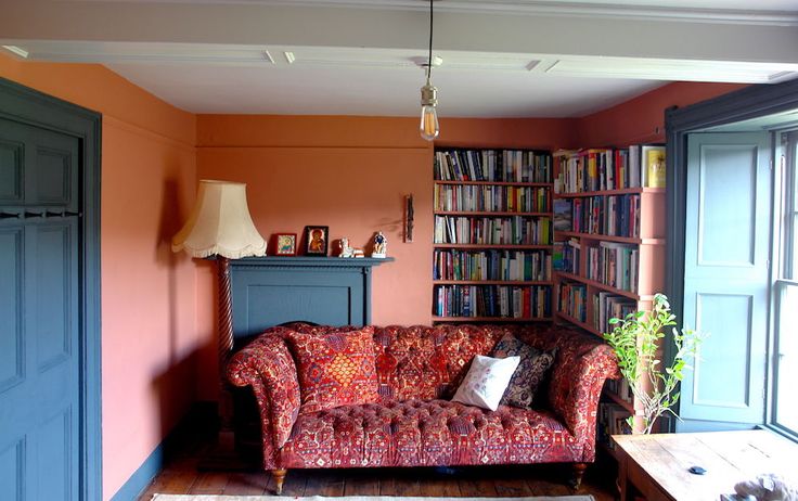 a living room with a red couch and bookshelf