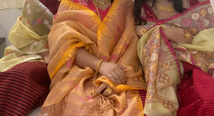 two women sitting next to each other in colorful clothing