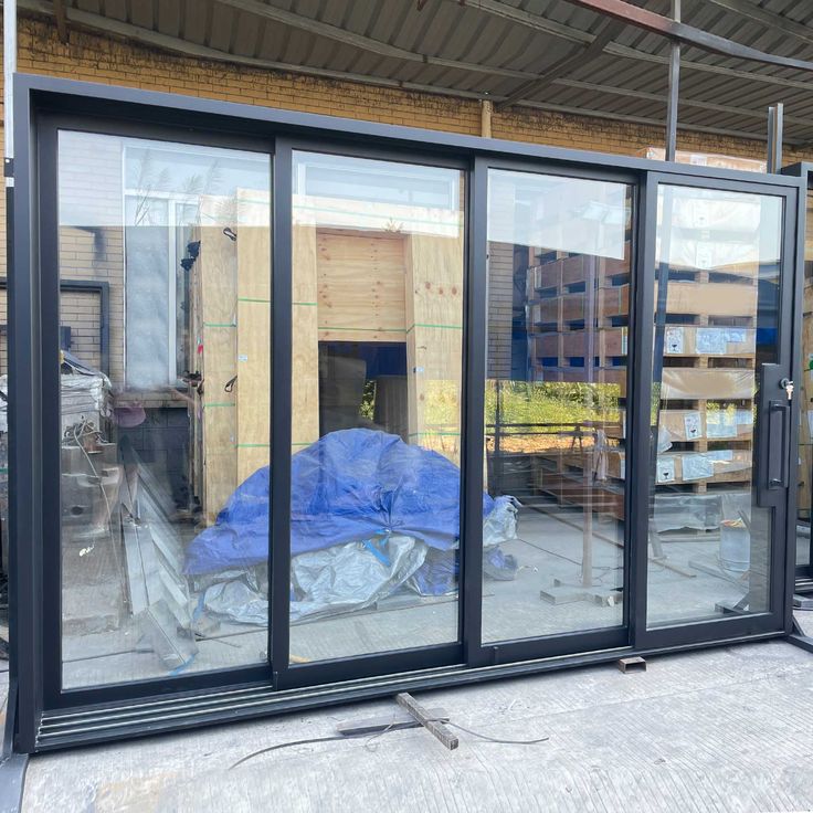 an image of a building being built with glass doors and windows on the side of it