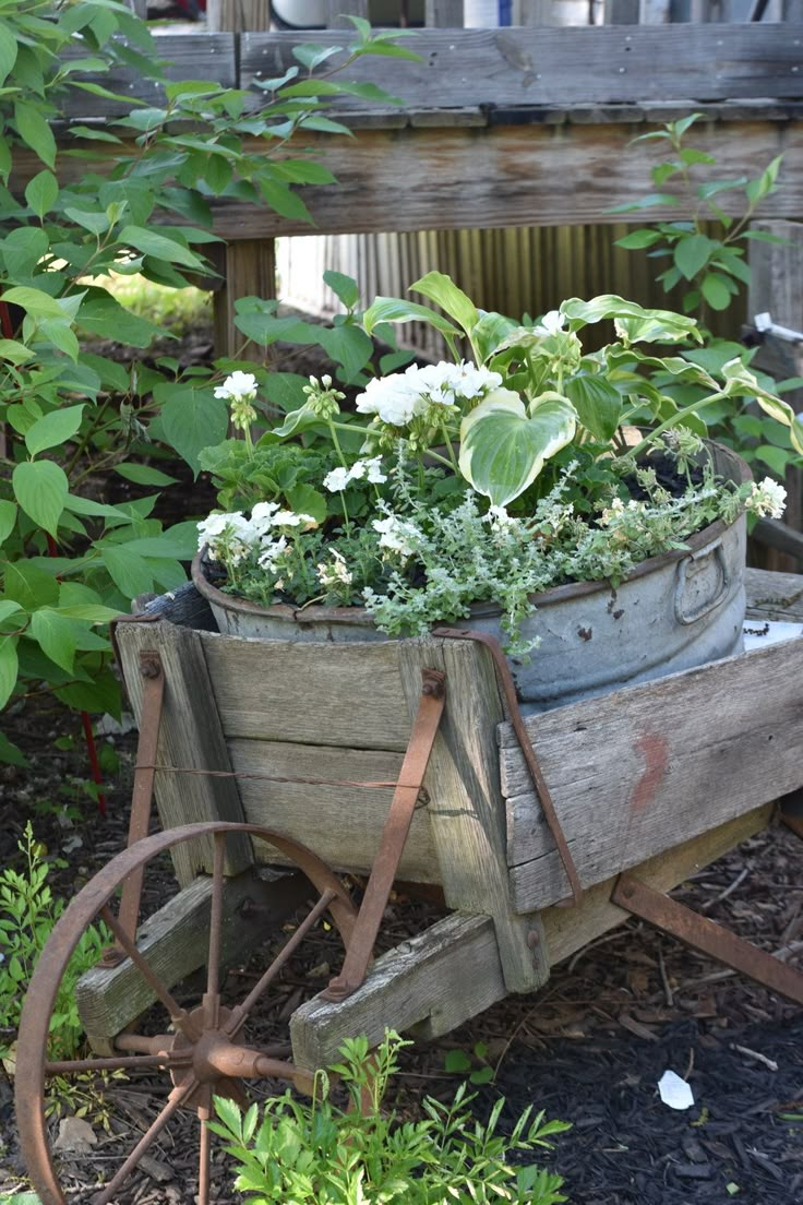 an old wooden wagon filled with flowers and plants