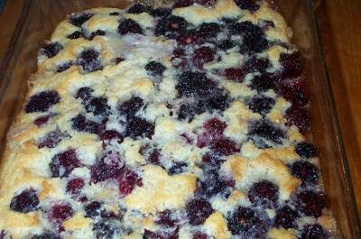 a pan filled with blueberry cobble sitting on top of a wooden table