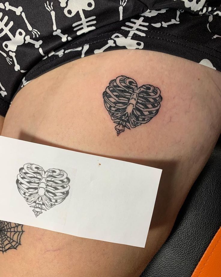 a woman's stomach with a tattoo on it and a piece of paper in the shape of a heart