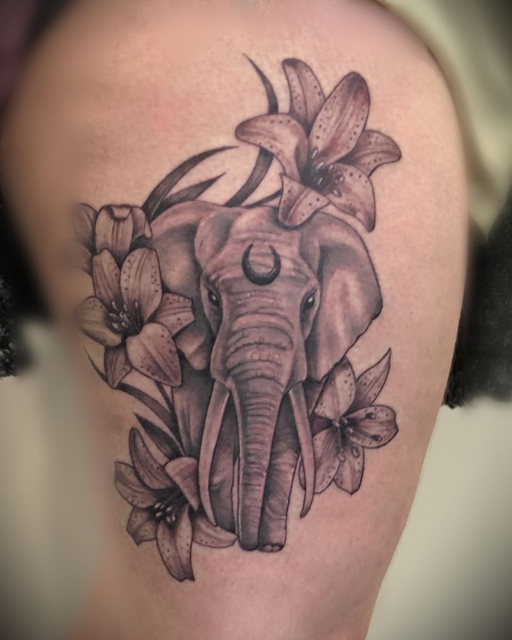 an elephant and flowers tattoo on the thigh