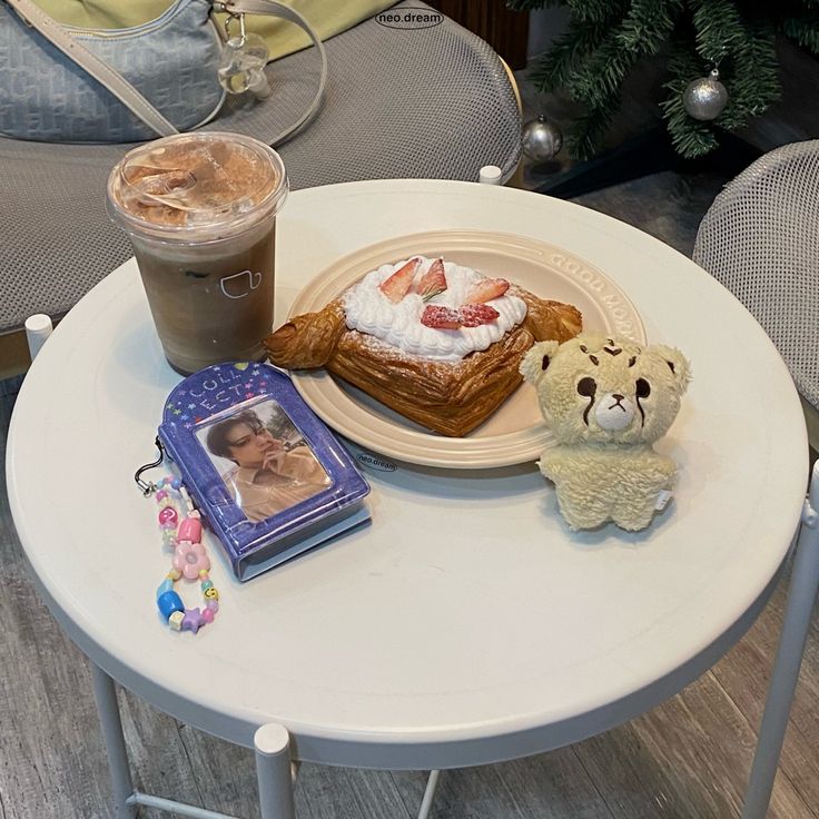 a table with a teddy bear, cake and coffee on it