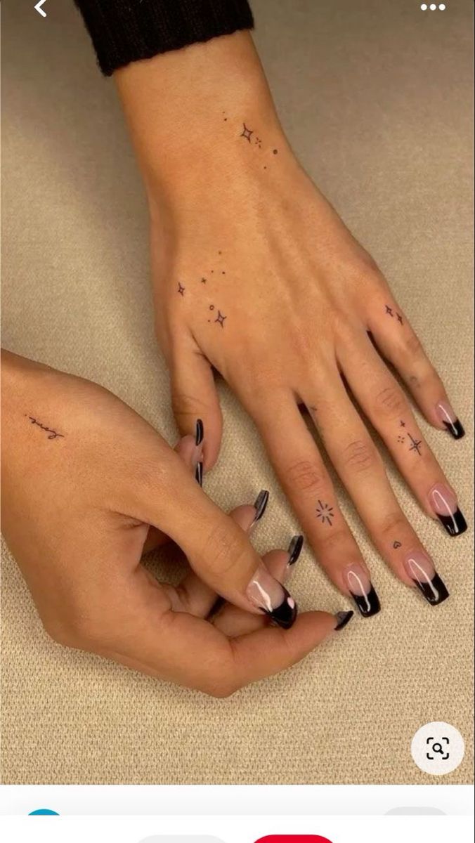 two hands with black and white nail designs on them