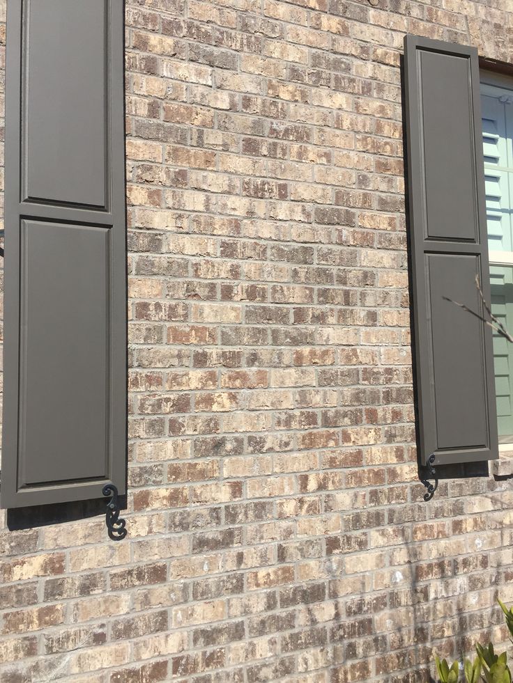 two windows on the side of a brick building