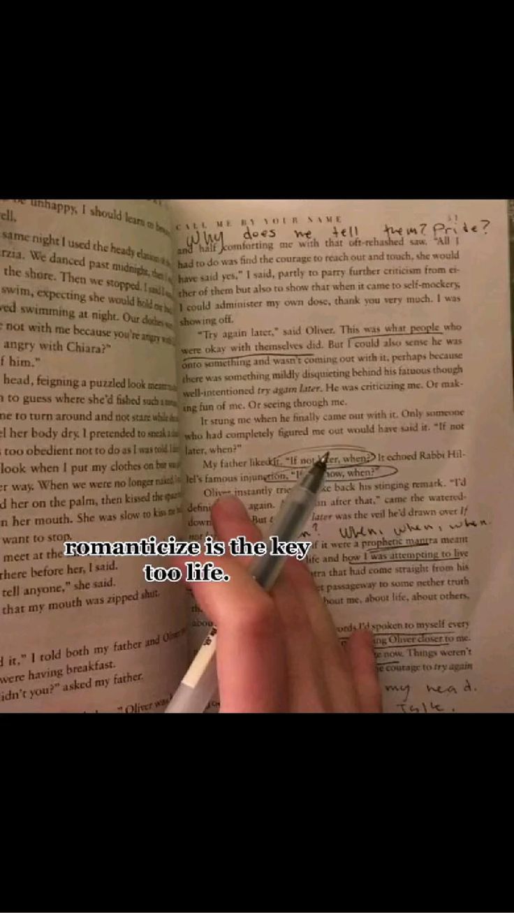 someone is writing on an open book with a pen