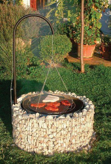 an outdoor fire pit in the middle of some grass