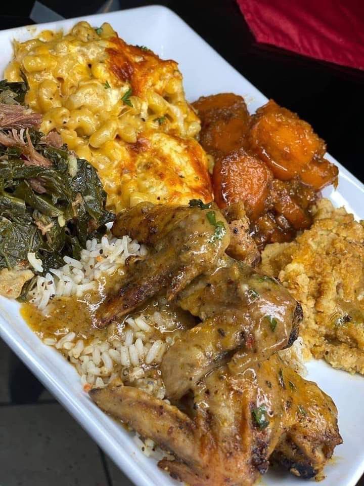 a white plate topped with meat, rice and veggies next to other foods