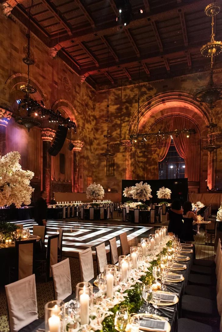 a long table is set up with white flowers and candles for an elegant dinner party