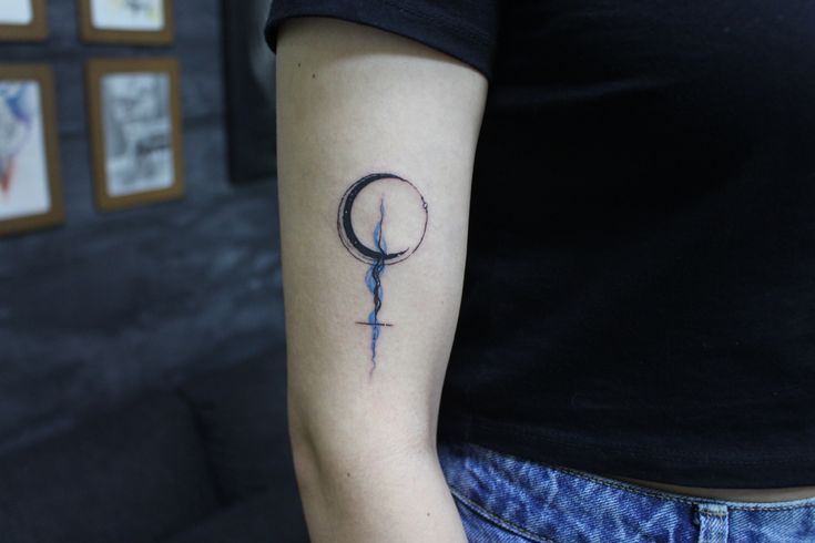 a woman's arm with a tattoo on it that has a crescent and star