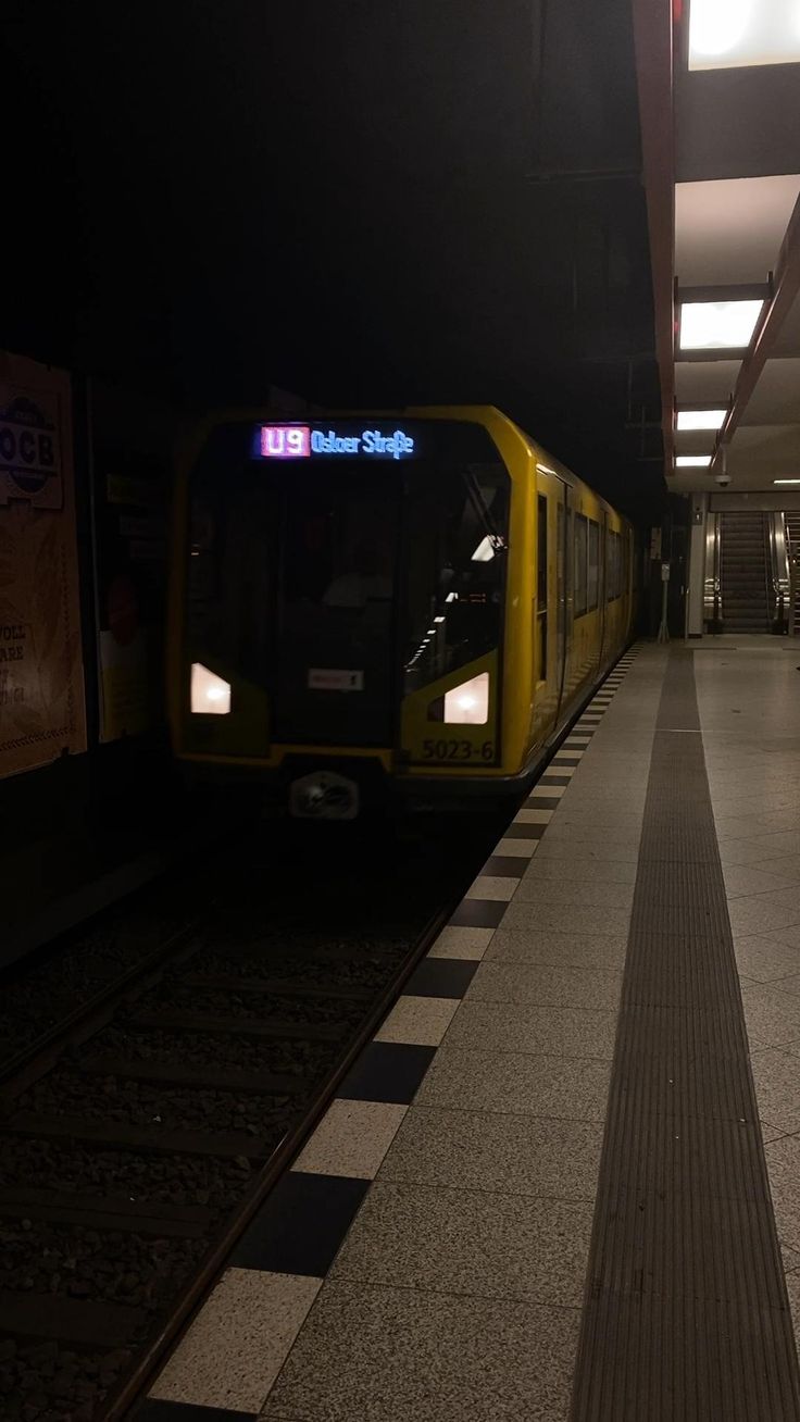 a subway train pulling into the station at night