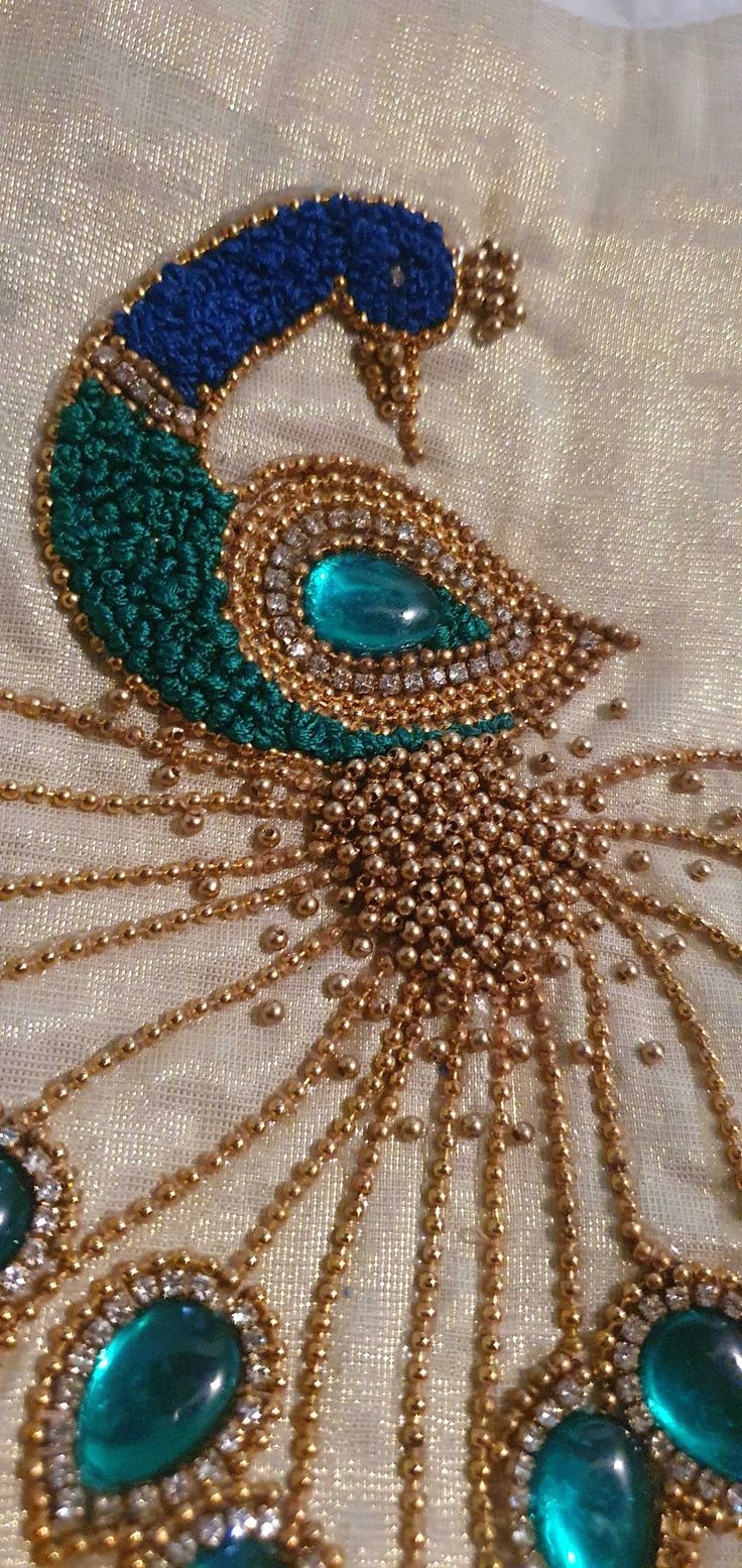 an embroidered peacock with blue and green beads