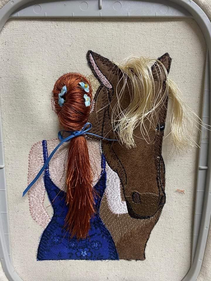 a horse and a woman on a piece of fabric with scissors in their hair, sitting next to each other