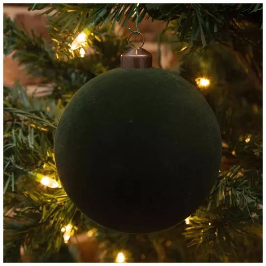 a green ornament hanging from a christmas tree