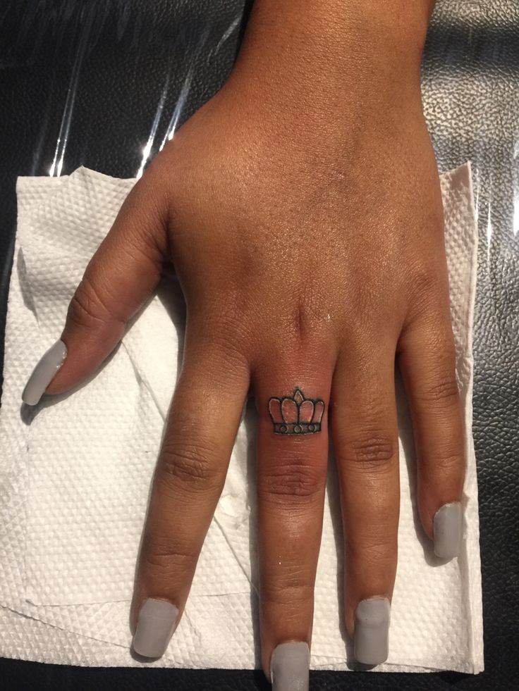 a woman's hand with a crown tattoo on it