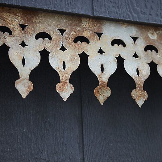 rusted metal hearts hanging from the side of a wooden building with black paint on it