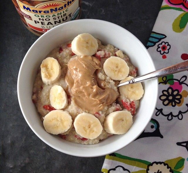 a bowl filled with oatmeal and bananas next to a jar of peanut butter