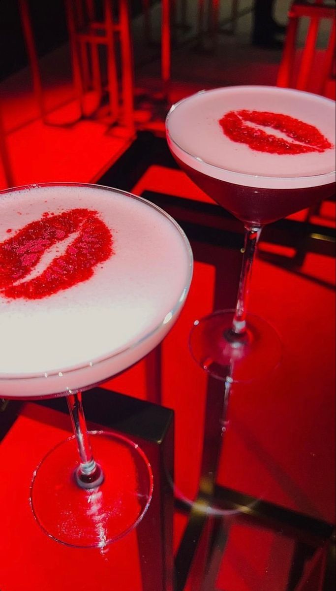 two martini glasses with red liquid on them