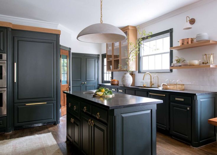 a kitchen with black cabinets and an island in front of the stove top oven is shown