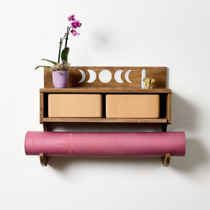 a shelf that has some flowers on top of it and a pink object next to it