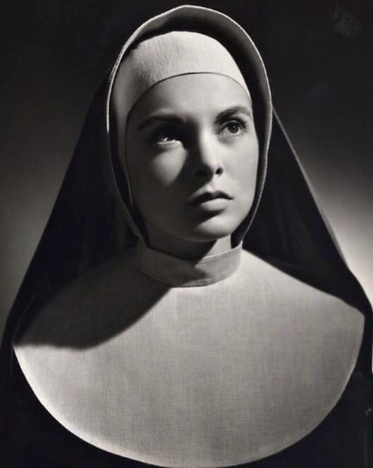 an old black and white photo of a woman wearing a nun's headdress