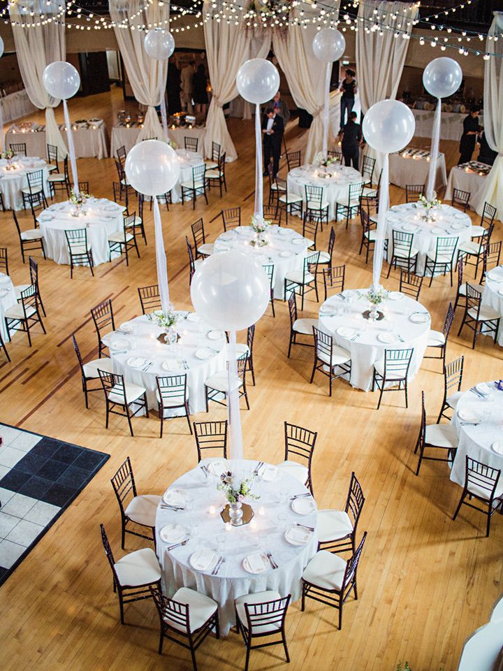 an overhead view of tables and chairs in a banquet hall with white balloons on the ceiling