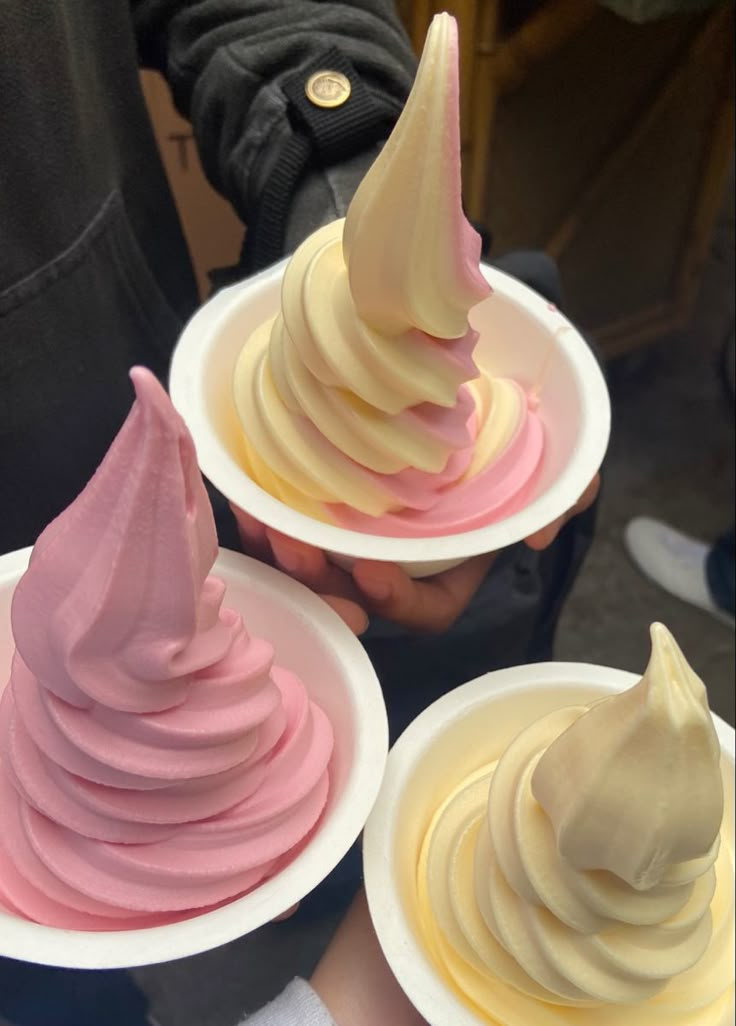 three plates with different colored ice creams on them, one is white and the other is pink