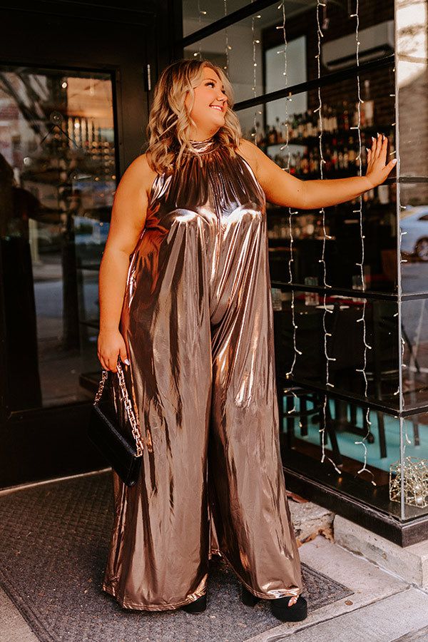 - Make a bold style statement with this glam jumpsuit! - Sleek, metallic, gold colored material - A built-in lining that ends thigh length - A mock neckline with back tie closure with a keyhole detail - Low back zip closure - A sleeveless cut - An ultra-relaxed silhouette that ends in wide floor length hemlines Gold Jumpsuits And Rompers For Summer Party, Gold Jumpsuit And Romper For Summer Party, Metallic Shimmer Jumpsuits And Rompers For Party, Glamorous Gold Jumpsuits And Rompers For Party Season, Metallic Sleeveless Jumpsuit For Night Out, Glamorous Metallic Shimmer Jumpsuits And Rompers, Glamorous Metallic Jumpsuits And Rompers For Night Out, Metallic Sleeveless Jumpsuits And Rompers For Party, Chic Gold Jumpsuits And Rompers For Night Out