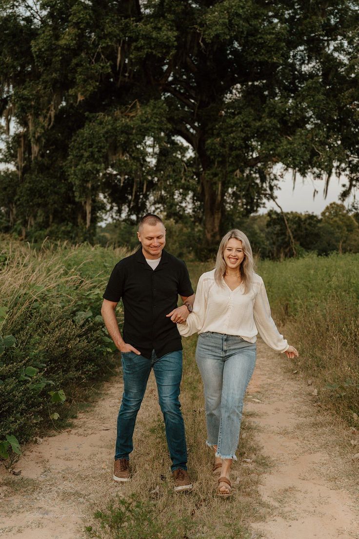 a man and woman walking down a dirt path