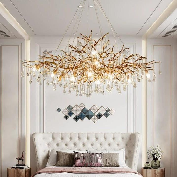 a white bed sitting under a chandelier in a bedroom