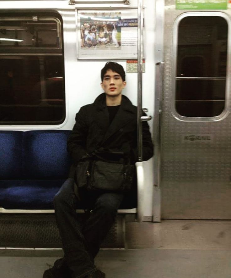 a young man sitting on a subway train