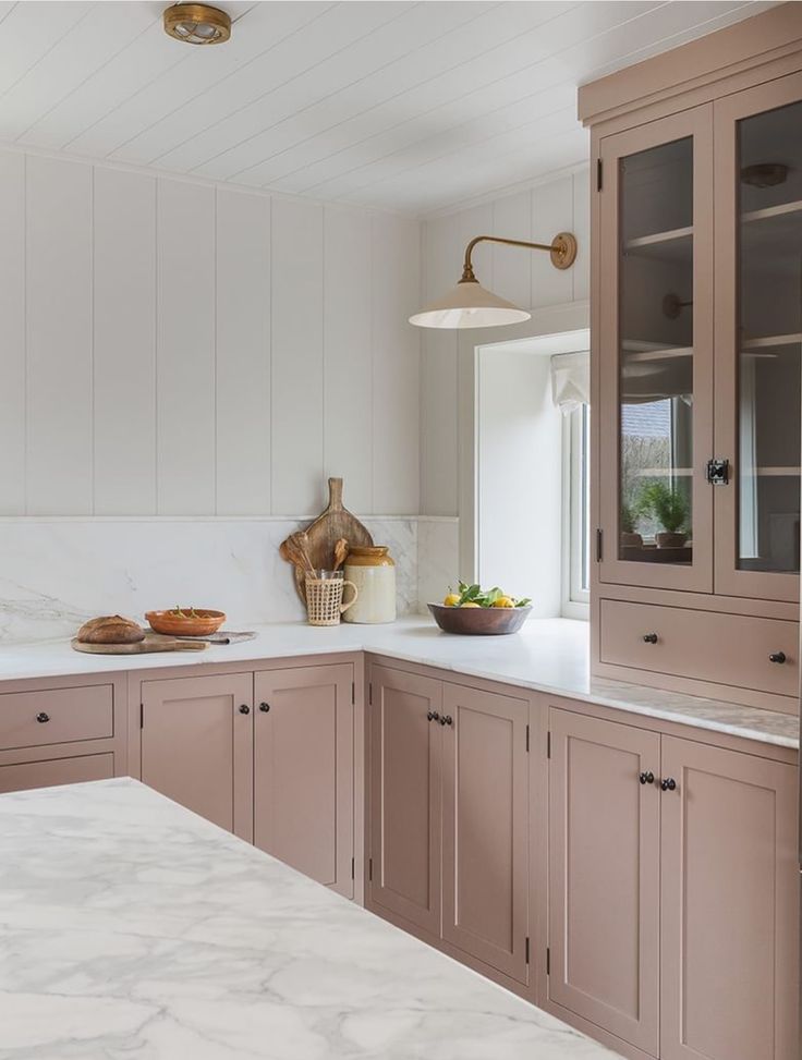 a kitchen with marble counter tops and wooden cabinets