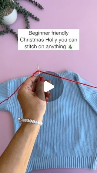 someone is knitting a christmas sweater with red string and white bead around the neck