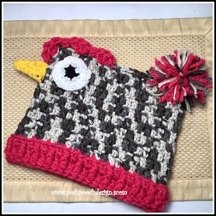 a crocheted hat with a bird on it and a pom - pom