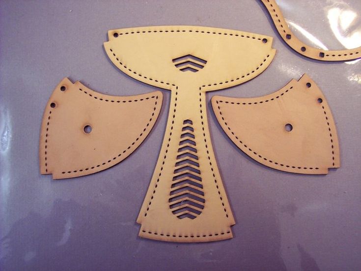 two pieces of leather with stitching in the shape of an inverted cross and arrow