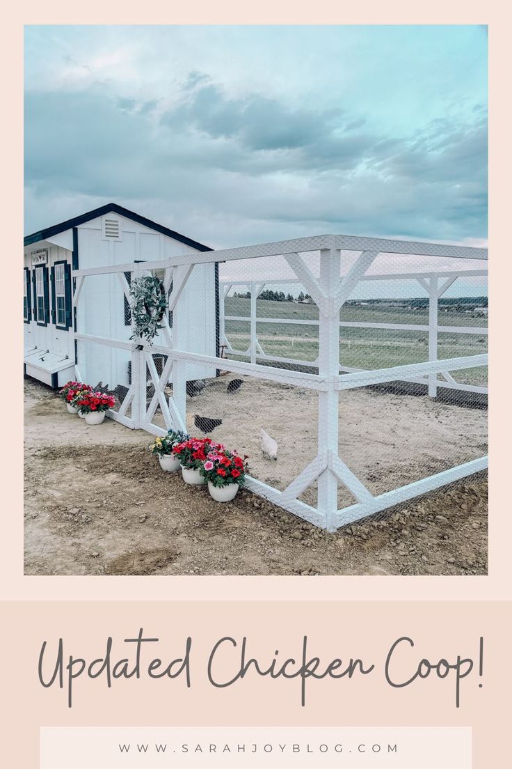 a white chicken coop sitting on top of a dirt field