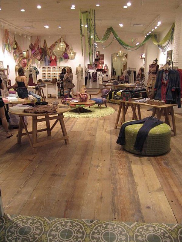 a room filled with lots of wooden tables and chairs in front of a store window