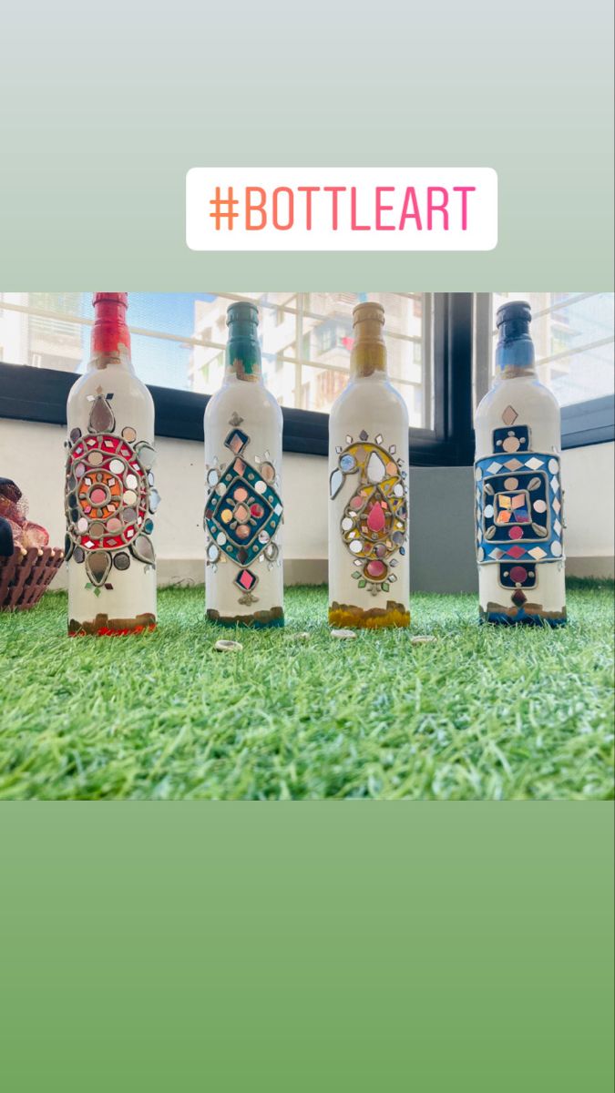 four bottles with designs on them sitting in the grass