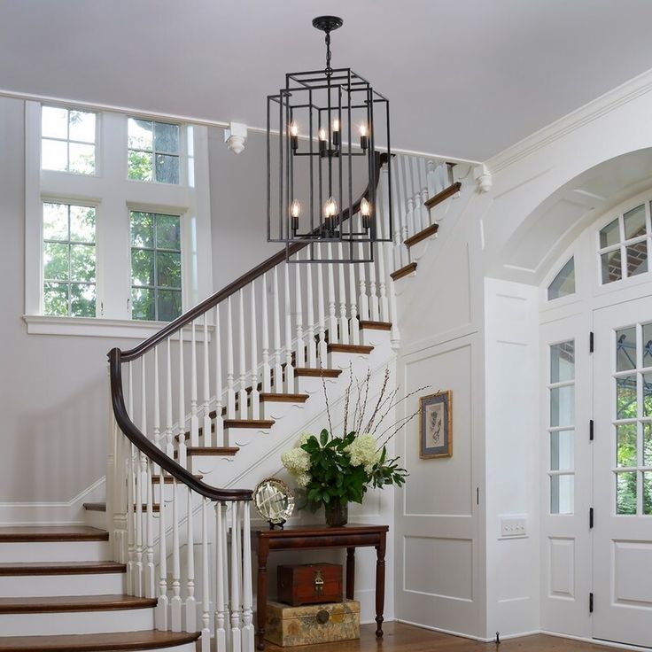 a foyer with stairs and a table in front of it