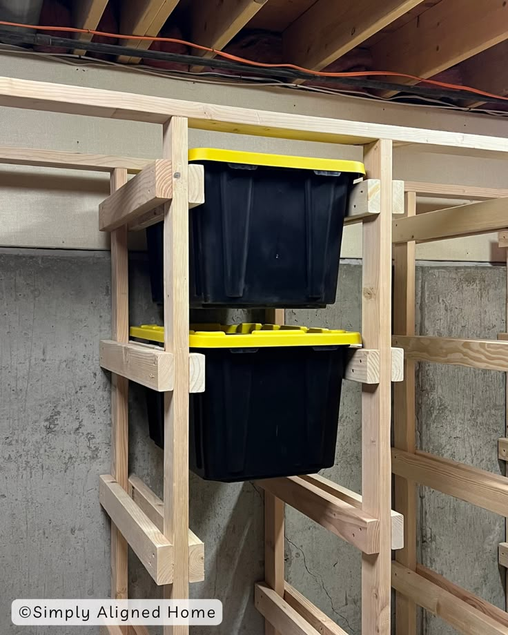 two buckets are hanging on the side of a wooden ladder in an unfinished room